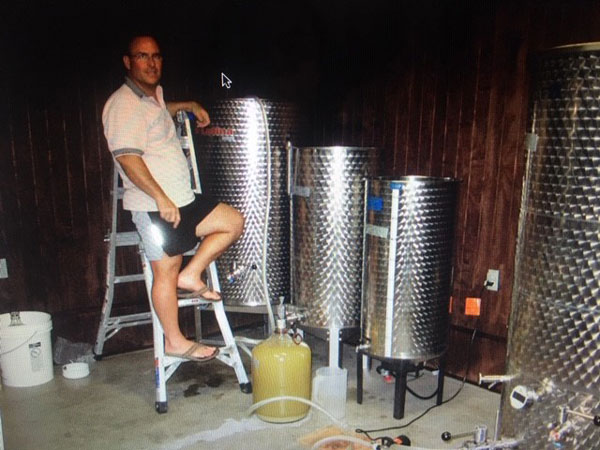 Westcave Cellars Winery owner Allan next to the first 4 small tanks at the winery.